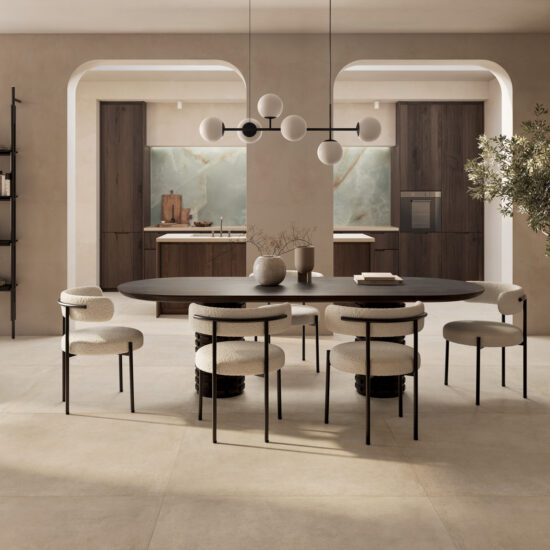 Interno elegante con un tavolo ovale e sedie tese. Cucina moderna in legno scuro e piante decorative. Atmosfera minimale e calda.